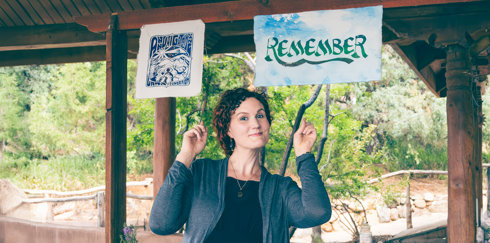 Rabea Benhalim playfully points to a sign that reads "renegade," showcasing her amusement and engagement with the message. (alt text by ahrefs.com)